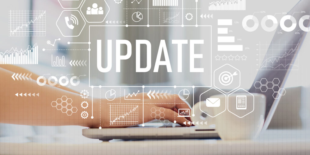 The word 'Update' in front of a pair of hands typing on a laptop