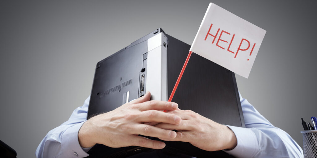 A person hugging a computer with a flag that says Help