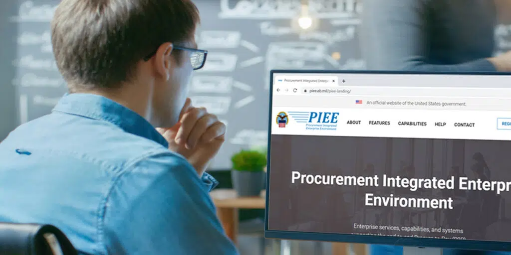 A person looking at a screen that says 'Procurement Integrated Enterprise Environment's' homepage