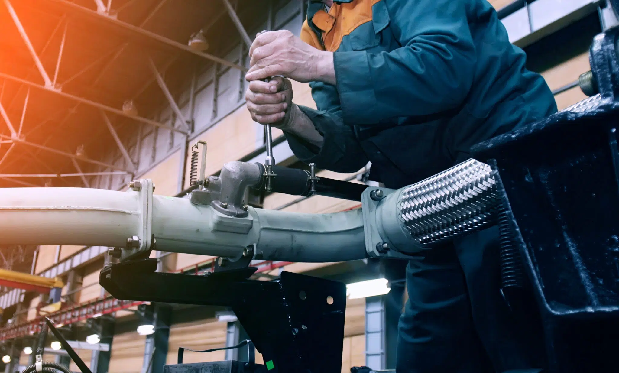 Man with tool over machinery