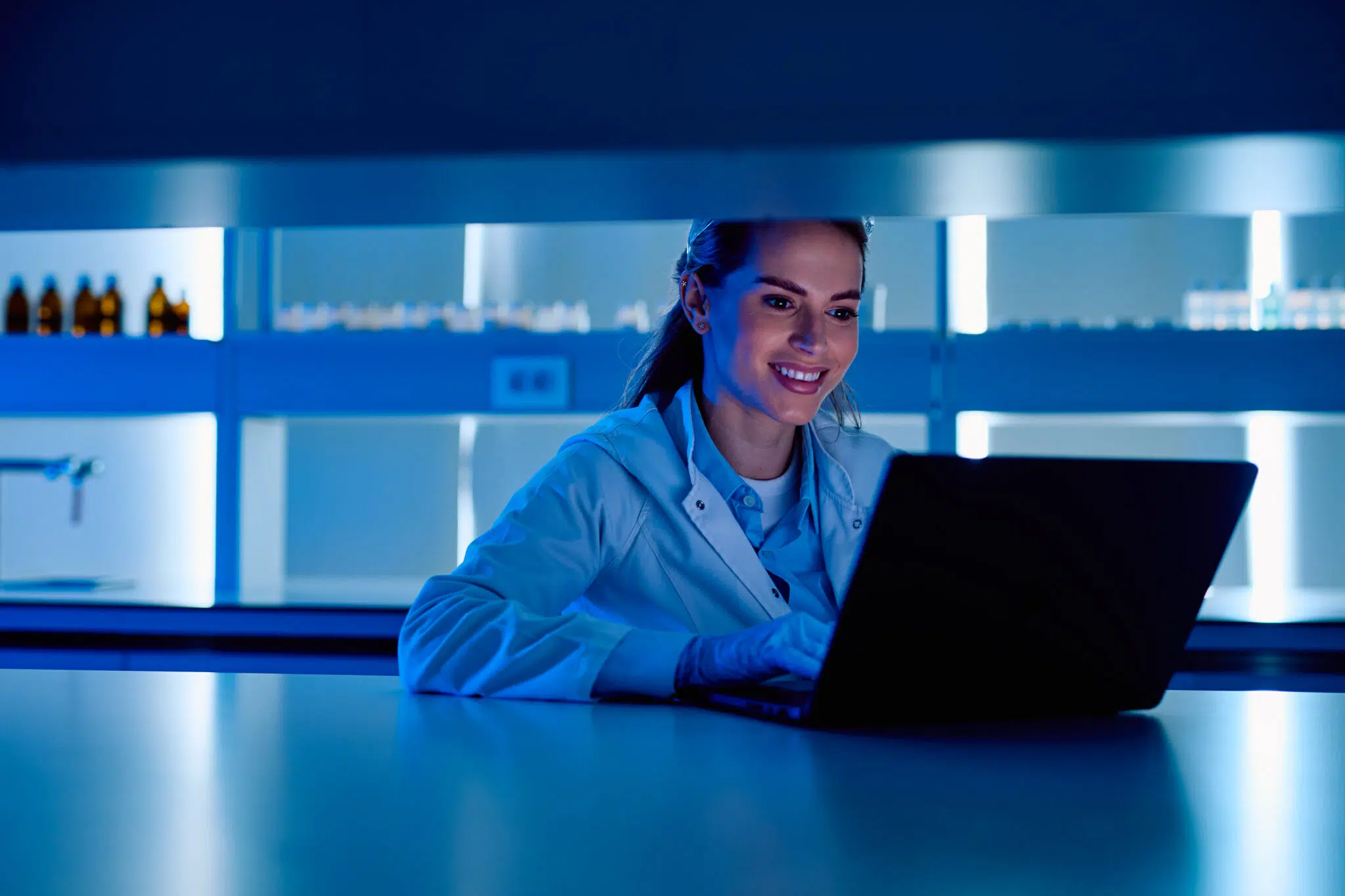 Woman in lab looking at laptop