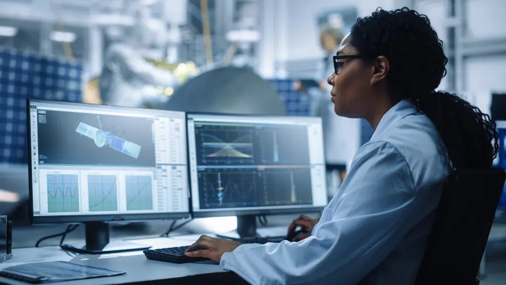 Woman in front of two monitors viewing satellite plan